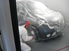 A painter preparing a masked-up car in the Scotspray spray booth