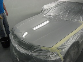 A car masked and ready for paint in the booth
