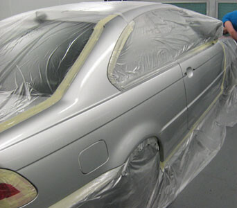 BMW coupe masked for paint in the booth