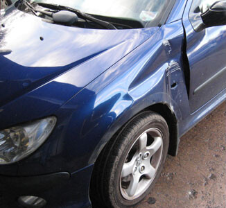 A blue Peugeot with impact damage to the front wing and door